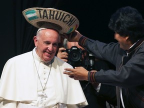 Pope Francis receives a typical sombrero from Bolivian President Evo Morales during a World Meeting of Popular Movements in Santa Cruz, Bolivia, July 9, 2015. The word "Tahuichi" is from the Tupi-Guarani and means "Big Bird". (REUTERS/Alessandro Bianchi)