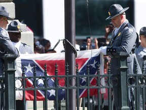 An honour guard from the South Carolina Highway patrol removes the Confederate battle flag from the Capitol grounds in Columbia, S.C., Friday, July 10, 2015, ending its 54-year presence there. AP Photo/John Bazemore