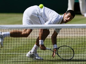 Novak Djokovic makes a return to Richard Gasquet during their men's singles semifinal match at Wimbledon in London on Friday, July 10, 2015. (Kirsty Wigglesworth/AP Photo)