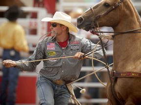 Tuf Cooper of Decatur, Texas, is pictured during the tie-down roping event at the Calgary Stampede in Calgary, Alta., on July 4, 2014. (Al Charest/Calgary Sun/Postmedia Network)