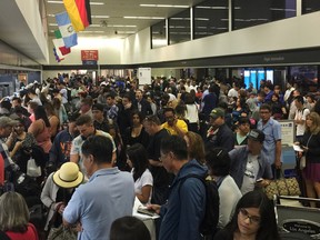 People gather at Los Angeles International Airport as United Airlines experienced computer problems in Los Angeles, Wednesday, July 8, 2015. A United spokeswoman said that the glitch was caused by an internal technology issue and not an outside threat or hacker. (Aristomenis Tsirbas via AP)