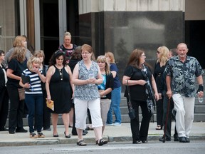 Victims and their families walk across the street from the federal courthouse after testimony was heard in the sentencing hearing of cancer doctor Farid Fata, Monday, July 6, 2015 in Detroit. Fata was sentenced to 45 years in prison for fraud on Friday. David Guralnick/Detroit News via AP