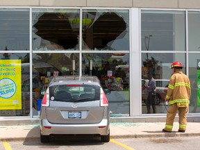 Andy Kobarda of the London fire department surveys the damage after a minivan slammed into the Shoppers Drug Mart at Highbury Avenue and Huron Street Friday afternoon, injuring a customer inside the store. (MIKE HENSEN, The London Free Press)