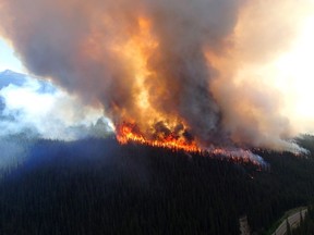 A wildfire rises over a hill in Jasper National Park on Thursday July 9, 2015. An evacuation of part of Jasper National Park has been ordered due to a forest fire in the picturesque Maligne Valley. THE CANADIAN PRESS/HO-Jasper National Park of Canada