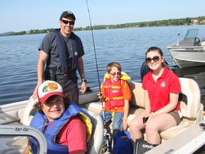 Declan Baslon (left), officer Mitch Brunette, Zaven Prevost and Ali MacKinnon prepare to take off to catch some fish during the annual Cops, Kids and Canadian Tire Fishing Days, which took place Friday at Whitewater Lake in Azilda.