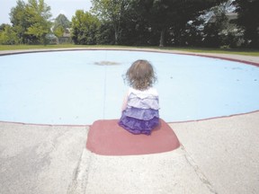 Three-year-old Lila Boyd sits at the edge of an empty wading pool at Smith Park in London, where the city has been forced to close six wading pools due to a lack of lifeguards. (DEREK RUTTAN, The London Free Press)