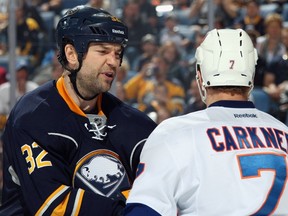 John Scott #32 of the Buffalo Sabres has words with Matt Carkner #7 of the New York Islanders at First Niagara Center on April 13, 2014 in Buffalo, New York.   Jen Fuller/Getty Images/AFP