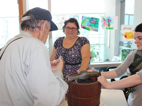 Melissa Wakeling (centre) of Glanmore National Historic Site talks to a patient at Belleville General Hospital Friday afternoon as Glanmore summer student Shannon Millar looks on. A group of patients who suffer from dementia or symptoms associated with the illness spent the afternoon making ice cream. Wakeling, education coordinator at Glanmore says the ice cream is used to help bring back memories.
