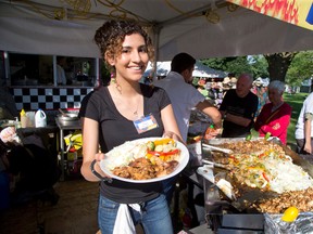 Walaa Yasin serves up a plate of European Style Grilled Chicken at Sunfest. (DEREK RUTTAN, The London Free Press)