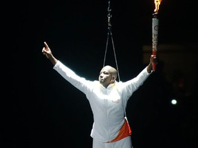Former Olympic champion sprinter Donovan Bailey is lowered to the stage  with the Pan Am flame during the opening ceremonies of the Pan Am games at the Rogers Centre. (MICHAEL PEAKE, Toronto Sun)