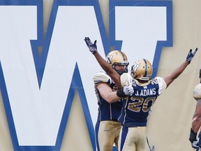 Winnipeg Blue Bombers' Johnny Adams (20) celebrates his interception touchdown with Greg Peach (90) against the Montreal Alouettes during the first half of CFL action in Winnipeg Friday, July 10, 2015. 
THE CANADIAN PRESS/John Woods
