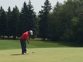 Eugene Wong rolls in his par putt on the 18th hole at Pine Ridge Golf Club on Saturday to secure a 62 that tied the course record. (Ken Wiebe/Winnipeg Sun/Postmedia Network)