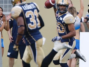 Winnipeg Blue Bombers' Johnny Adams (20) celebrates his interception as he runs it in for the touchdown against the Montreal Alouettes during the first half of CFL action in Winnipeg Friday, July 10, 2015. (THE CANADIAN PRESS/John Woods)