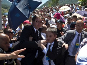 Aleksandar Vucic, Serbia's prime minister, centre, is seen during a scuffle at the Potocari memorial complex near Srebrenica, on July 11, 2015. (AP Photo/Marko Drobnjakovic)