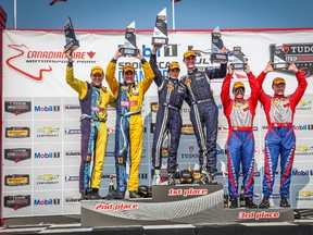Austin Cindric and Jade Buford (centre) hoist their first-place trophies along with second-place finishers Matt and Hugh Plumb (left) and third-place finishers Andrew Davis and Robin Liddell at Saturday’s Continental Tire SportsCar Challenge in Bowmanville. (JOHN WALKER/PHOTO)
