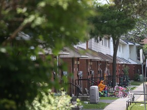 A mother sits outside her home at the Albion-Heatherington community in Ottawa on Tuesday July 7, 2015. The city of Ottawa is trying to decide which city needy, low-income community should receive funding for projects. 
Tony Caldwell/Ottawa Sun