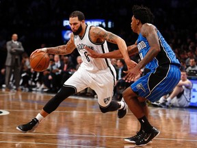 In this Nov. 9, 2014, file photo, Brooklyn Nets' Deron Williams, left, drives against Orlando Magic's Elfrid Payto. Two people with knowledge of the arrangement tell The Associated Press that  Williams is set to join the Dallas Mavericks if the point guard clears waivers after reaching a buyout with the Nets. Williams will sign with the Mavericks once he clears waivers Monday, the sources said Friday. (AP Photo/Jason DeCrow, File)