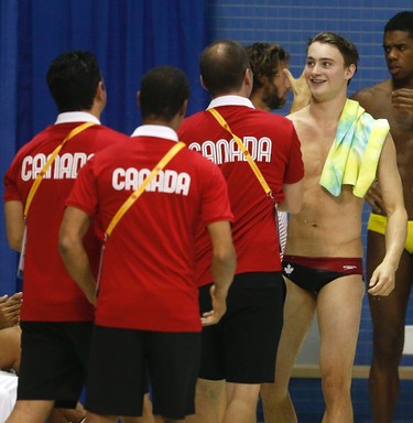 Canadian diver Philippe Gagne is congratulated by team staff after winning a bronze medal in the 3 metre springboard the at the Pan Am Aquatic Centre in Toronto on Saturday July 11, 2015. Michael Peake/Toronto Sun/Postmedia Network