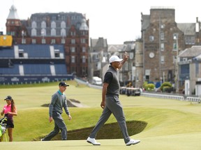 Tiger Woods waves to the crowd on the 17th green at St Andrews, Scotland, Saturday, July 11, 2015. (AP Photo/Peter Morrison)