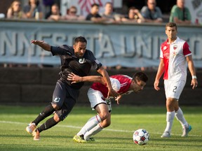 Ottawa Fury FC’s Andrew Wiedeman (centre) tries to hold off Ibson of Minnesota United FC last night in NASL action. (Minnesota United Photo)