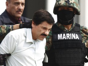 Joaquin Guzman is escorted by soldiers during a presentation at the Navy's airstrip in Mexico City in this February 22, 2014 file photo. Mexico's most notorious drug lord Joaquin "El Chapo" Guzman has escaped from his high security prison in central Mexico, the country's national security commission (CNS) said on July 12, 2015. REUTERS/Edgard Garrido/Files