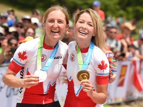 Catharine Pendrel, of Canada, (left) and Emily Batty (right), of Canada, celebrate with their medals on the podium after the women's mountain bike cycling final during the 2015 Pan Am Games at Hardwood Mountain Bike Park July 12, 2015. (John David Mercer-USA TODAY Sports)