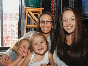Five-year old Myla Harvey, left, three-year old Kylee  Harvey, mom Natasha Harvey and 17-year old Cassandra  Harvey pose for a family portrait in their home in Kingston, Ont. on Saturday July 11, 2015. The family has just returned home to Kingston after spending two months in Ottawa at Children’s Hospital of Eastern Ontario where Kylee has been receiving treatment for a serious heart condition.  Julia McKay/The Kingston Whig-Standard/Postmedia Network