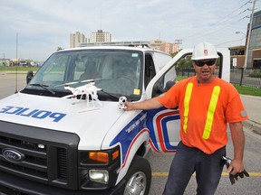 An unidentified London Hydro worker shows off a London's man's drone that fell from the sky and struck a London police van Sunday. Joe O'Neil had offered the utility crew a bird's-eye view of hot spots along overhead wires using his $1,500 drone, but was horrified when its electronics fried and the miniature helicopter plunged and struck the van. (Special to The Free Press)