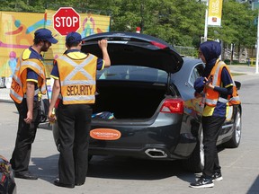Officially marked Pan Am Games vehicles are checked under strict security before the cars enter the underground parking lot at Exhibition Place on Saturday, July 11, 2015. (Veronica Henri/Toronto Sun)