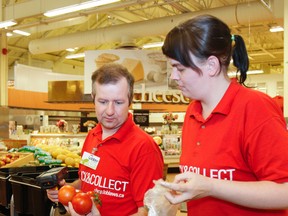 Loblaws Click-and-Collect personal shoppers, Glen Loverock and Linda Guay select some fresh tomatoes to bag during a practise order at the Cataraqui Loblaws location in Kingston, Ont. on Friday July 10, 2015. The online shopping program launches at the local store on Monday, July 13. Julia McKay/The Kingston Whig-Standard/Postmedia Network
