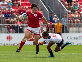 Napanee’s Brittany Benn, left, skips past Hannah Lopez of the United States to score a try during a women's rugby sevens preliminary game at the Pan Am Games in Toronto on Sunday. (Chris Young/The Canadian Press)