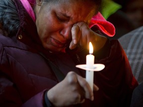 Eric Garner's widow Esaw Garner cries during a candlelight vigil at the site her husband Eric Garner died, during a Martin Luther King Jr. day service in the Staten Island borough of New York in a January 19, 2015 file photo. New York City has reached a settlement with the family of Eric Garner, who was killed after being put in a chokehold by police last July, agreeing to pay $5.9 million to resolve the claim over his death, city officials said on Monday. Eric Garner's death, along with the fatal shooting of an unarmed 18-year-old black man in Ferguson, Missouri, last August by a white police officer, sparked protests around the country by people outraged over police treatment of African-Americans.    REUTERS/Carlo Allegri/files