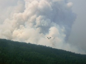 A water bomber works on the Cog wildfire near Lac La Ronge, Saskatchewan in a photo released by Government of Saskatchewan July 13, 2015. The Canadian military has been called in to help fight wildfires in the Western province of Saskatchewan, where over 100 active fires have forced the evacuation of more than 13,000 people and threatened several remote towns.  REUTERS/Government of Saskatchewan/Handout via Reuters