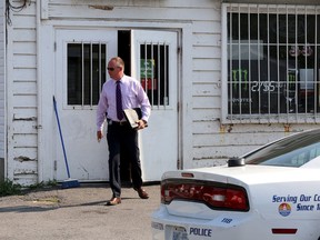 Kingston Police Det. Const. Clint Wills leaves David's Convenience store at 72 Thomas Street after a robbery  in Kingston on Monday July 13 2015. Ian MacAlpine/The Kingston Whig-Standard