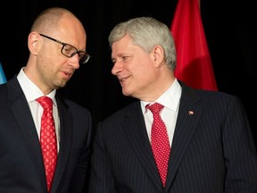 Prime Minister Stephen Harper, right, speaks with Ukrainian Prime Minister Arseniy Yatsenyuk during a signing ceremony at Willson house in Chelsea, Que., on July 14, 2015. (THE CANADIAN PRESS/Adrian Wyld)