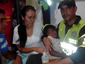 A police officer hugs Jessica Patricia Arias as she is accompanied by relatives, after being rescued by police members in Tayrona park close to Santa Marta, Colombia July 13, 2015. Jessica went missing in northern Colombia's natural reserve Tayrona Park when she was collecting coconuts with her parents. After an 18 day air and land search by hundreds of officers, the seven-year-old was located after an anonymous tip off was made to the family and a guard station at the park. Picture taken July 13, 2015. REUTERS/National Police/Handout Via Reuters