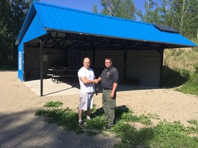 Evergreen Shooting Club president Logan Rode (left) shakes hands with Newalta representative Sean Phoenix (right). Newalta is one of the many donors that helped make the prone building a possibility.