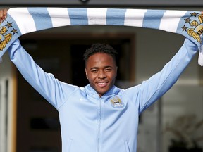 New Manchester City signing Raheem Sterling poses with a club scarf as he leaves the club’s Etihad Stadium in Manchester, Britain, July 14, 2015. (REUTERS/Andrew Yates)