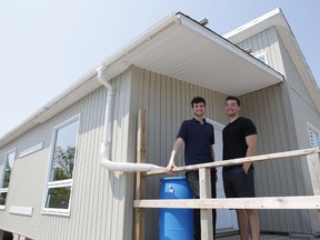 Queen's University third year students Connor Macorin, left, and Kevin Mulligan stand on the Queen’s Solar Design Team's demonstration house on the university's West Campus in Kingston, Ont. on Monday, July 13, 2015. Elliot Ferguson/Kingston Whig-Standard/Postmedia Network