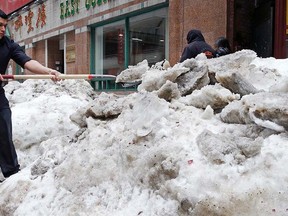 In this March 4, 2015 file photo, a man shovels snow outside a restaurant in the Chinatown neighbourhood of Boston. (AP Photo/Charles Krupa, File)