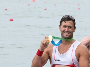 Kingston's Rob Gibson shows the gold medal he won as a member of Canada's quadruple sculls rowing crew at the Pan Am Games in St. Catharines on Tuesday. (Peter Power/The Canadian Press)
