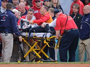 A fan, who was accidentally hit in the head with a broken bat by Athletics' Brett Lawrie, is helped from the stands during a game against the Red Sox at Fenway Park in Boston on June 5, 2015. (Charles Krupa/AP Photo/File)