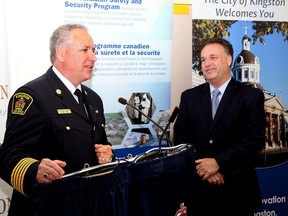 Kingston Fire and Rescue Chief Rheaume Chaput speaks during an announcement regarding Kingston and the surrounding area will soon have enhance communication systems in place that will help area municipalities help each other deal with emergencies at Kingston Police headquarters on Tuesday July 14 2015. Looking on is Leeds and Grenville MP Gord Brown. Ian MacAlpine/The Kingston Whig-Standard/Postmedia Network