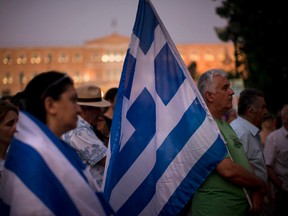 Demonstrators gather near the Greek Parliament during a rally against the government's agreement with its creditors in Athens, in central Athens, Tuesday, July 14, 2015. The eurozone's top official says it's not easy to find a way to get Greece a short-term cash infusion that will help it meet upcoming debt repayments. (AP Photo/Emilio Morenatti)