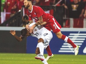 Team Canada’s David Edgar heads the ball over top of Costa Rica’s Johan Venegas during last night’s game at BMO Field. (CP)