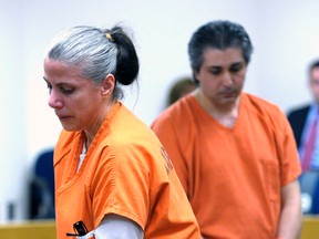 Valbona Lucaj, left, and her husband Sebastiano Quagliata return to their seats after addressing the court before their sentencing Tuesday, July 14, 2015 at Lapeer County Circuit Court in Lapeer , Mich. Sebastiano Quagliata, 46, and Valbona Lucaj, 45, were sentenced to nearly five years in prison Tuesday for failing to control dogs who killed a cancer survivor who was attacked while jogging on a rural road. (Danny Miller/The Flint Journal-MLive.com via AP)