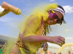 A participants reacts as a volunteer squirts colourful powder at her during "The Color Run" around Wembley Stadium in London on June 7, 2015. The Festival of Good Things in Sarnia is adding a Run of Exploding Colour to this year's event. It's set for the morning of Sept, 5, during the festival at the Sarnia Point Lands.
AFP PHOTO / JUSTIN TALLIS