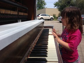 Four-year-old Stephanie Morris playing the Piano located at Front St