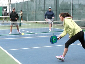 Senior athletes playing a game of pickleball.