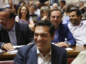 Greek Prime Minister Alexis Tsipras smiles before a ruling Syriza party parliamentary group session in Athens, Greece July 15, 2015. (REUTERS/Yannis Behrakis)